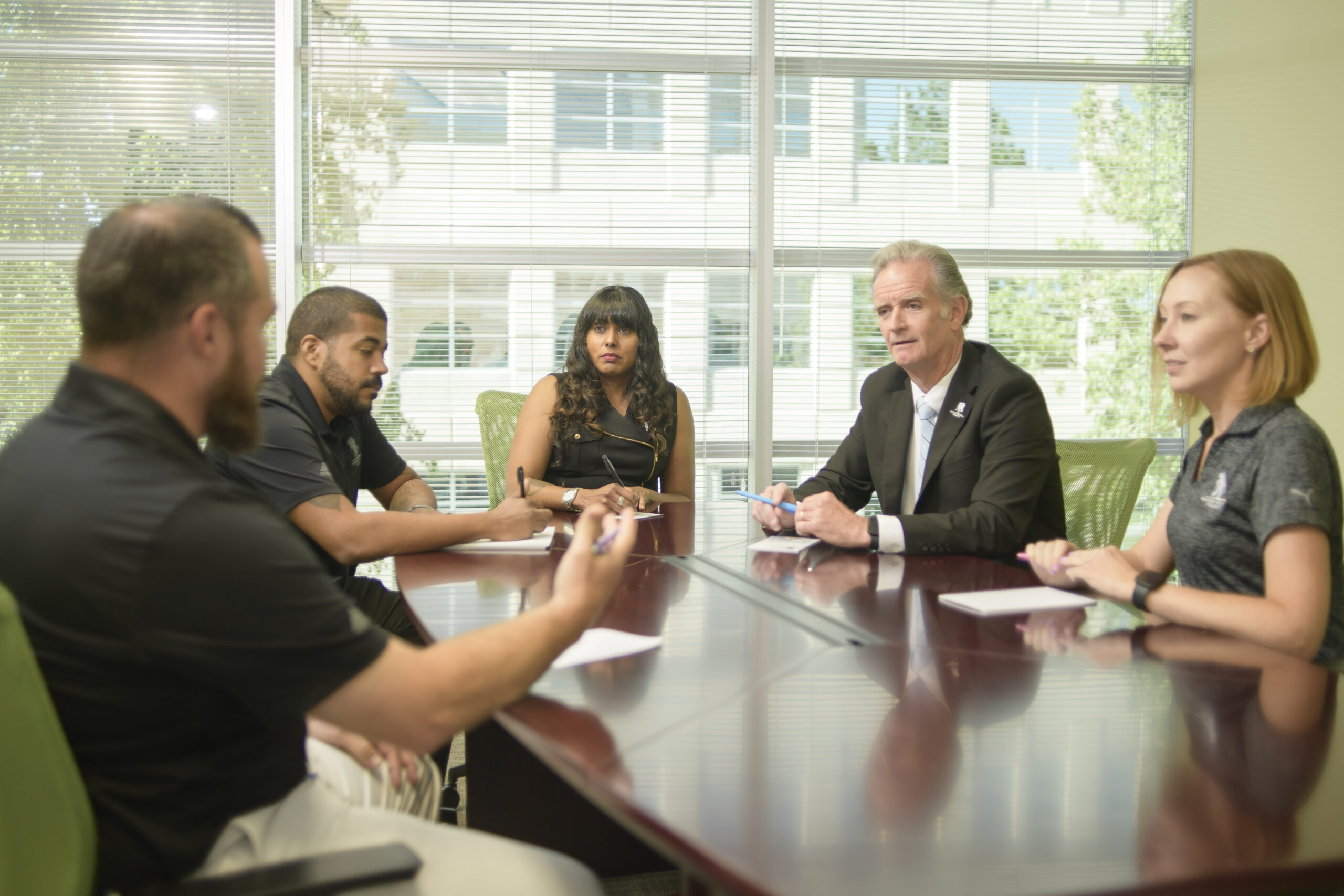 Walt Piatt, Wounded Warrior Project CEO sits and talks with others around a conference room table.