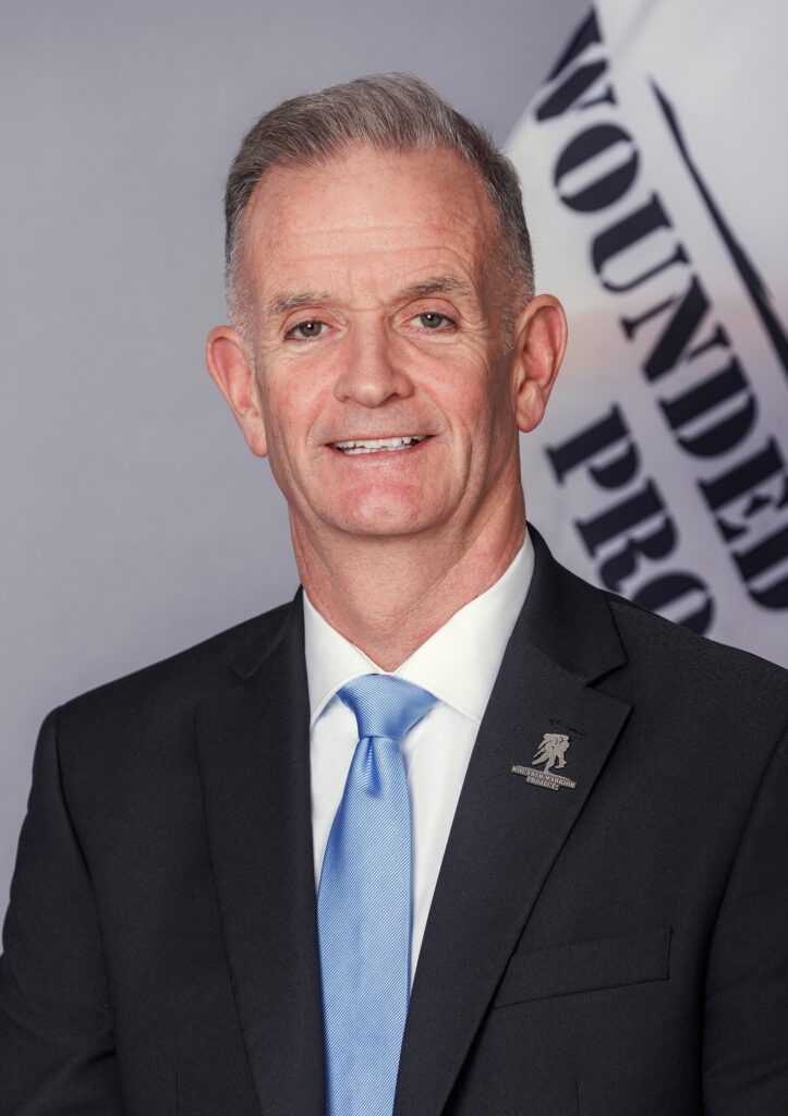 Headshot of Walt Piatt in front of Wounded Warrior Project flag.